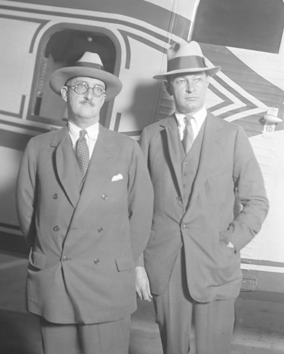 Ein Bild von zwei Männern vor einem Flugzeug. 