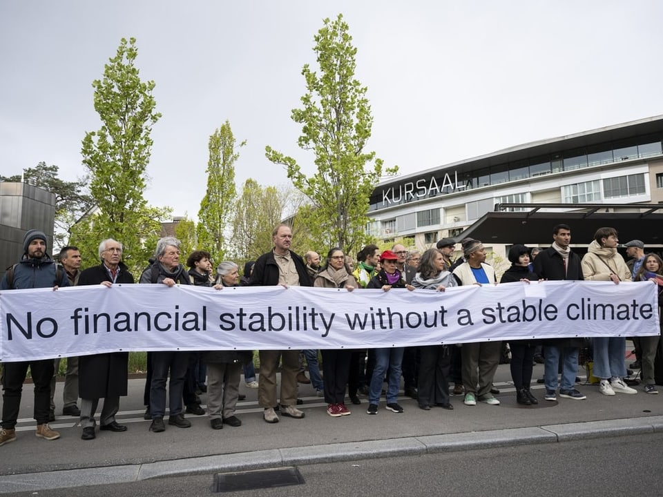 Demonstrierende halten ein Banner mit der Aufschrift «No financial stability without a stable climate»