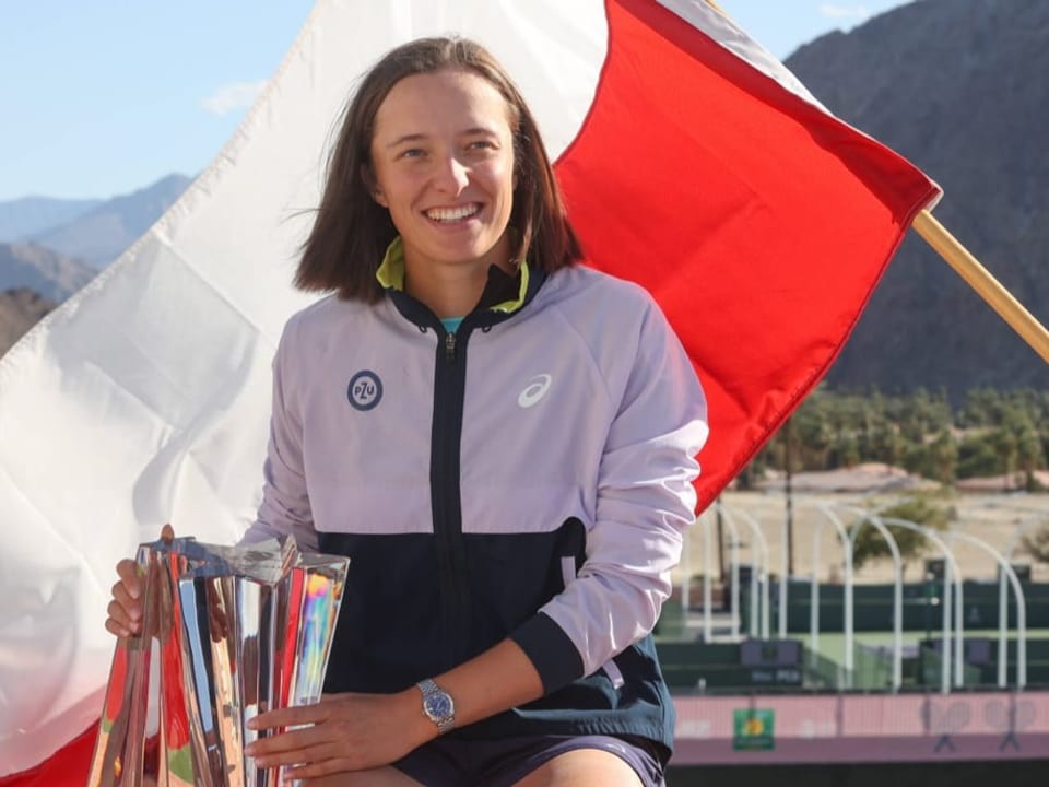 Könnte eine neue Ära an der Spitze des WTA-Rankings einläuten Iga Swiatek lächelnd mit Trophäe und vor der polnischen Flagge.
