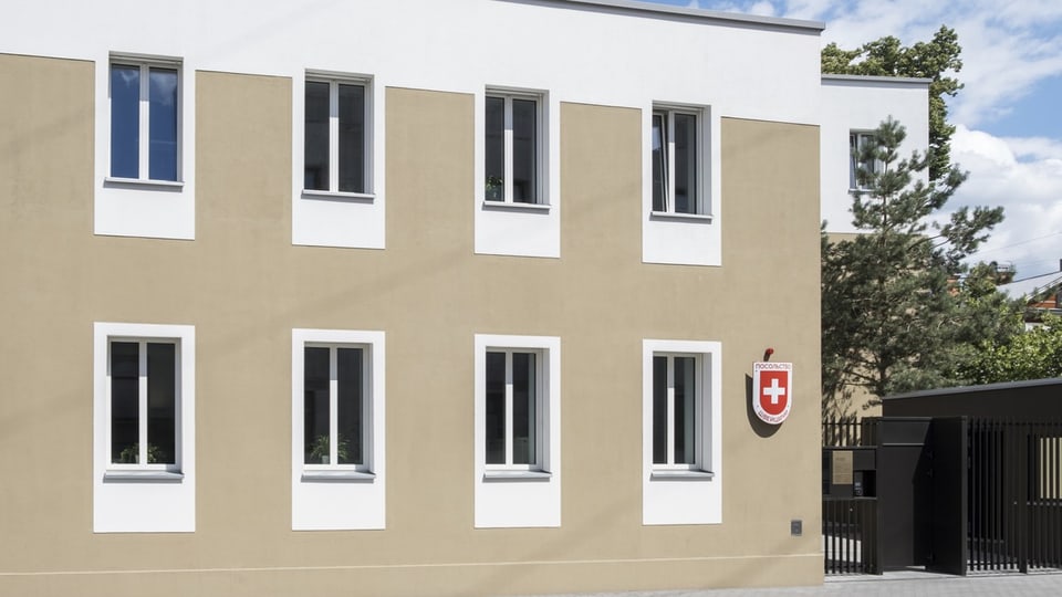 Ein Gebäude mit Sicherheitseingang und einem Schild mit Schweizerkreuz