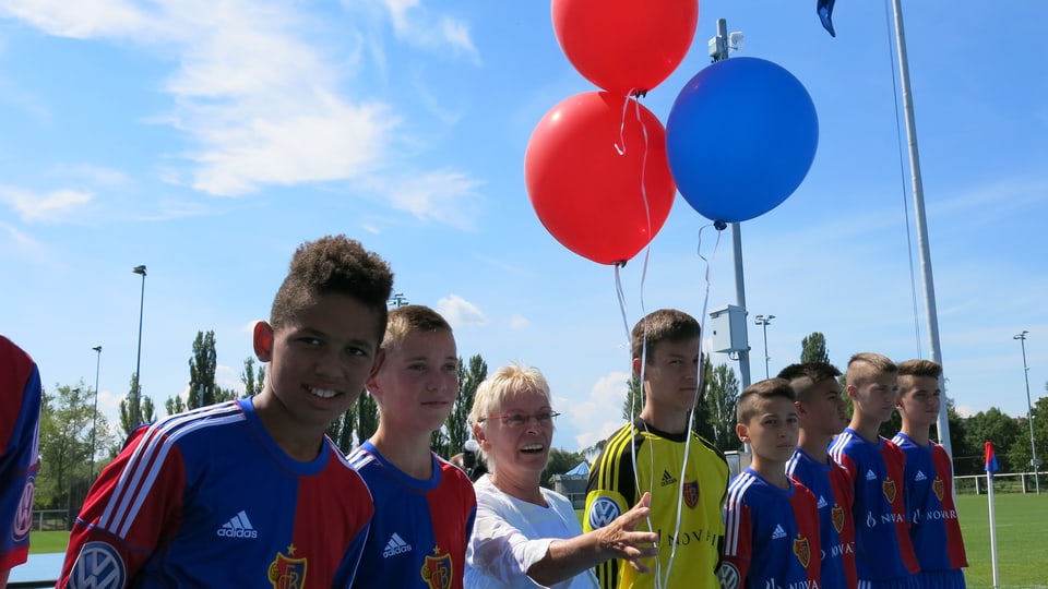 Gigi Oeri, inmitten von Junioren im FCB-Dress, lässt rote und blaue Ballone fliegen. 