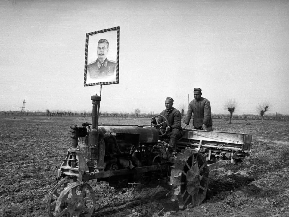 Bauern in Usbekistan in den 1930er Jahren: Am Traktor ist gross ein Bild von Stalin montiert.