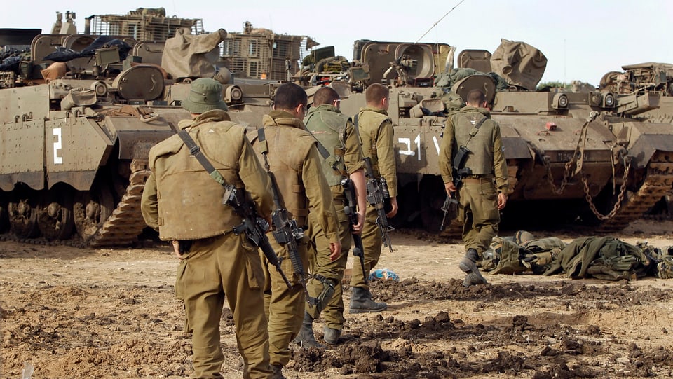 Israelische Soldaten marschieren auf abgestellt Panzer zu