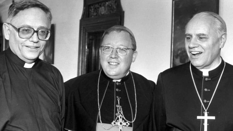 schwarzweiss-Foto drei Männer im Priestergewand, links mit grosser Brille, in der Mitte ein rundlicher, rechts lachend.