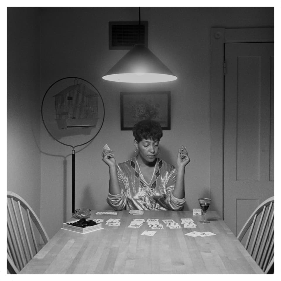 Eine Frau sitzt am Küchentisch und spielt Karten