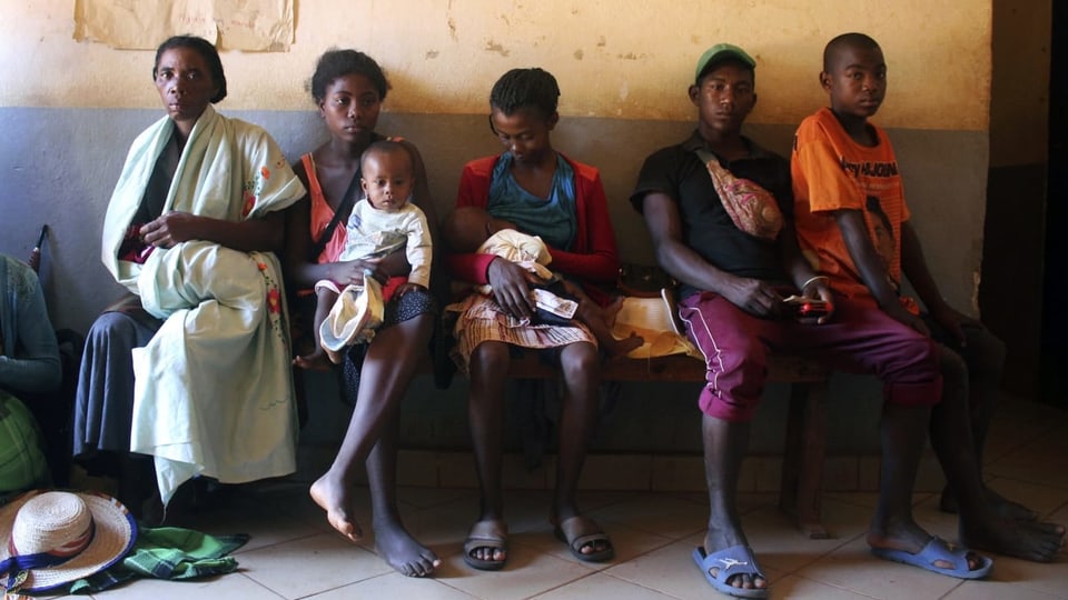 Madagassen mit Kindern, die sich impfen lassen