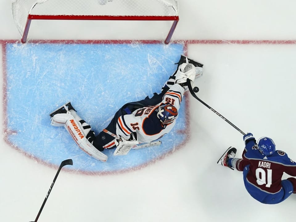 In der NHL wehrt Edmonton-Goalie einen Schuss von Colorado-Spieler Kadri ab.