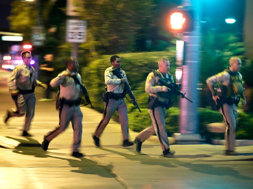 Mehrere Polizeibeamte rennen mit angelegten Waffen über eine Strasse beim Casino Tropicana in Las Vegas.