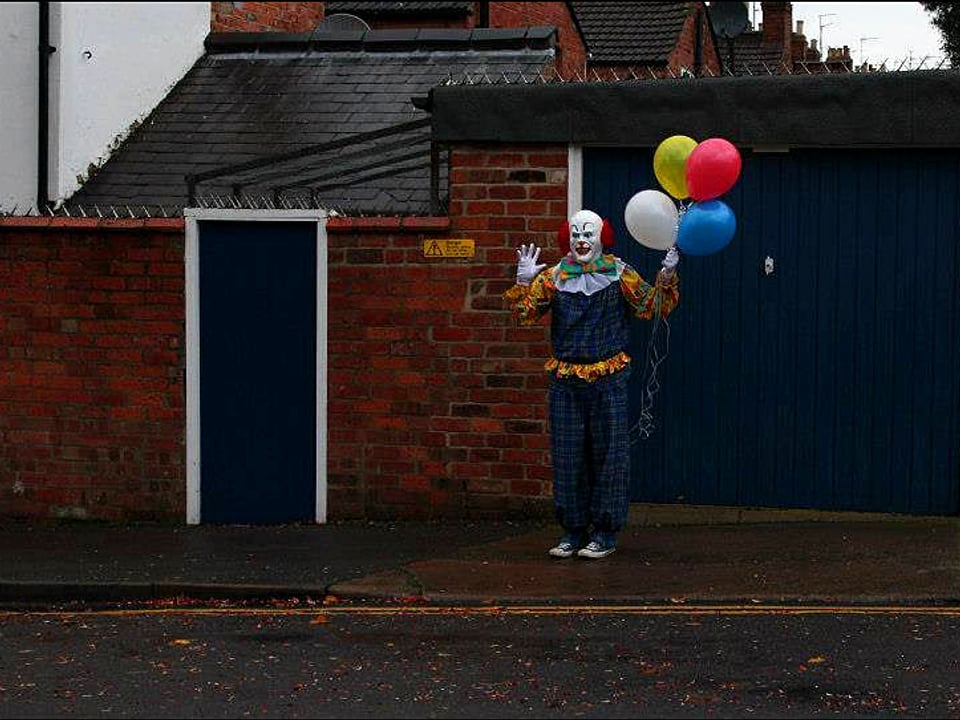 Clown mit farbigen Ballonen in der Hand