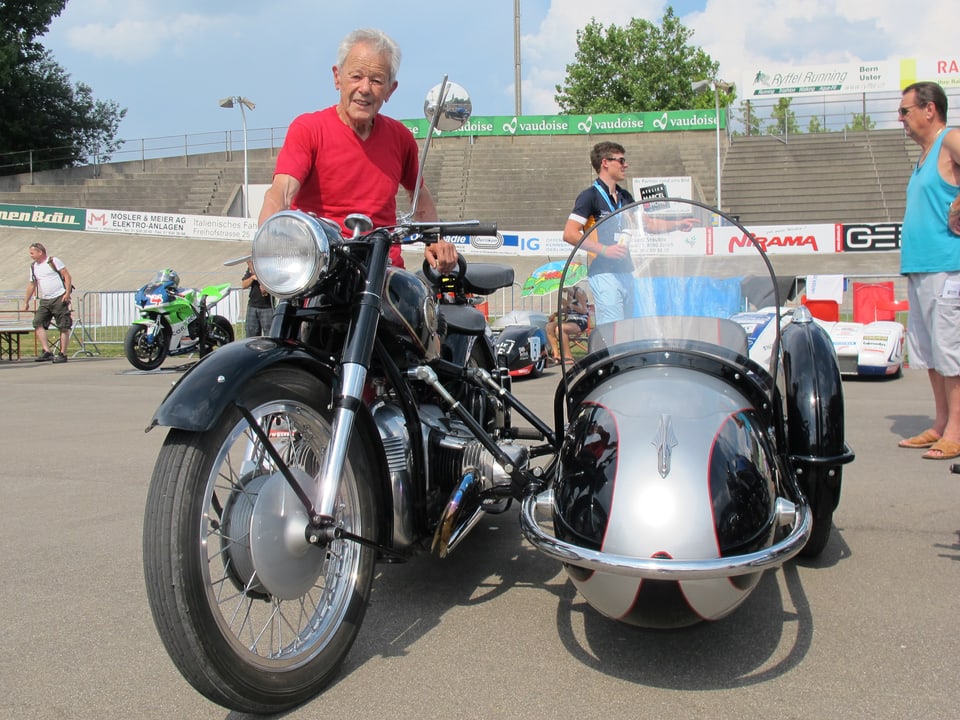 Der ehemalige Rennfahrer Luigi Taveri neben einem Seitenwagen-Motorrad.