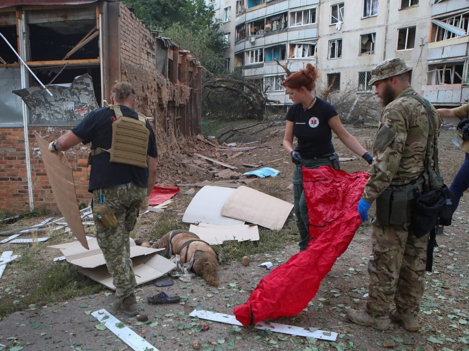 Sanitäter suchen in einem zerbombten Haus nach Verletzten.