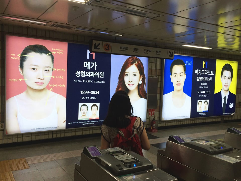 Werbung mit Vorher-Nachher-Bildern an einer U-Bahn-Station in Seoul.