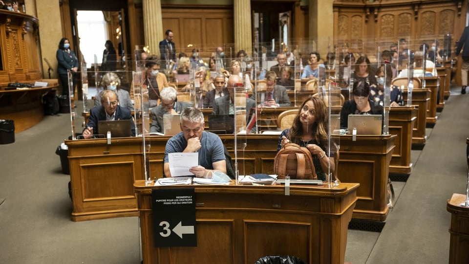 Blick in den Nationalratssaal, wo die Parlamentarier einzeln hinter Plexiglasscheiben sitzen.