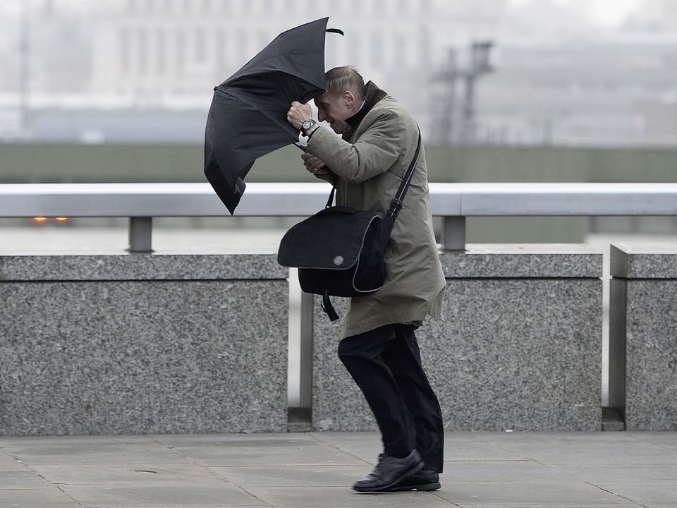 Ein Mann verliert auf der London Bridge in der britischen Hauptstadt die Kontrolle über seinen Regenschirm. (reuters)