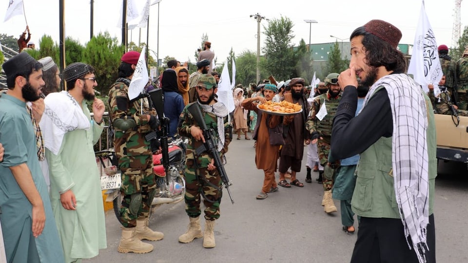 Eine Gruppe Männer feiert den Jahrestag der Machtübernahme der Taliban