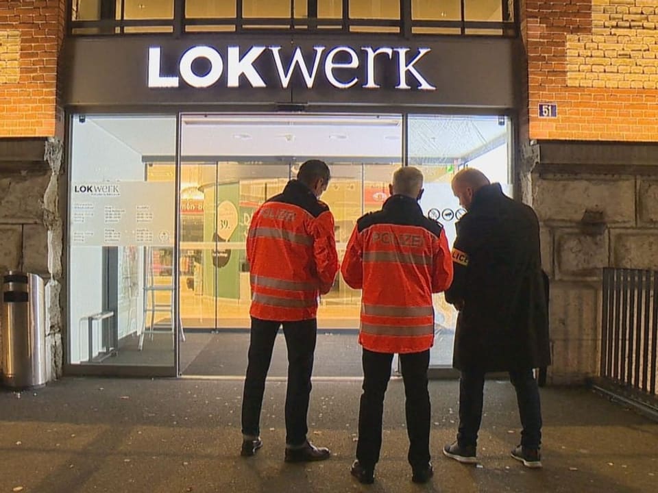 Polizisten stehen vor dem Tatort. 