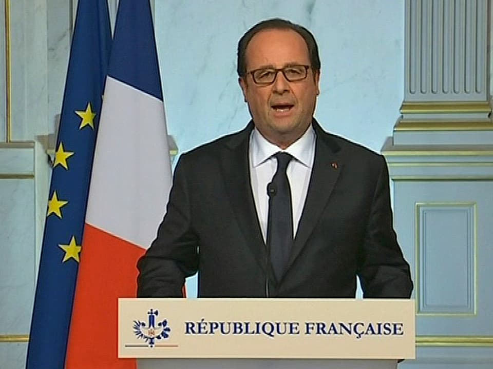 Hollande an einem Rednerpult.