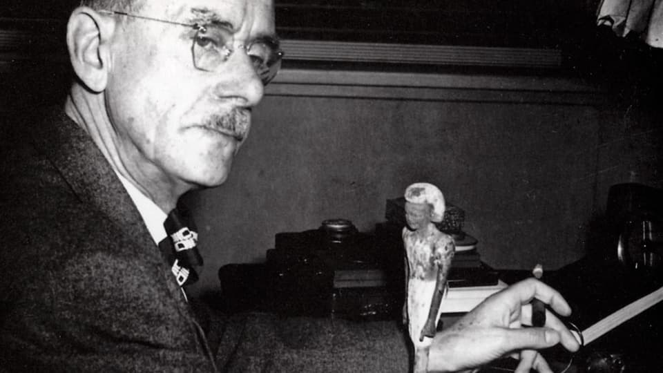schwarzweiss-Foto älterer Herr mit Brille und Stift in der Hand