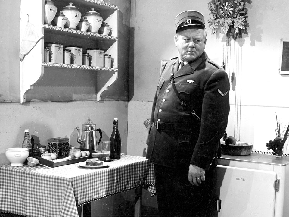 Ein Mann in Uniform steht in einer Küche. 