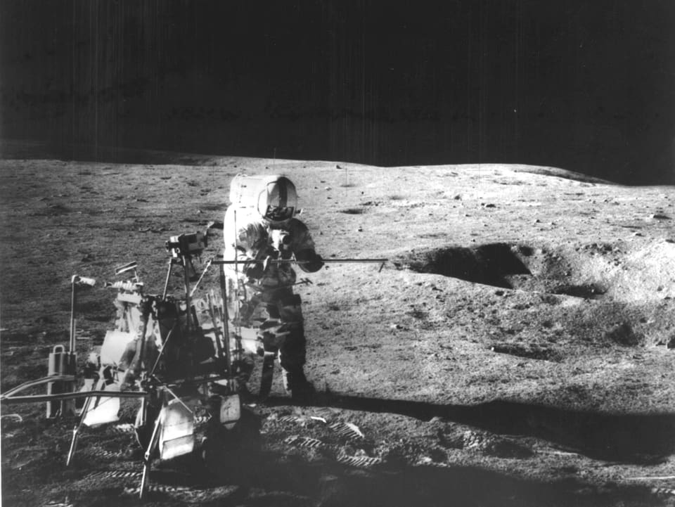 Sam Shepard nimmt auf dem Mond Bodenproben.