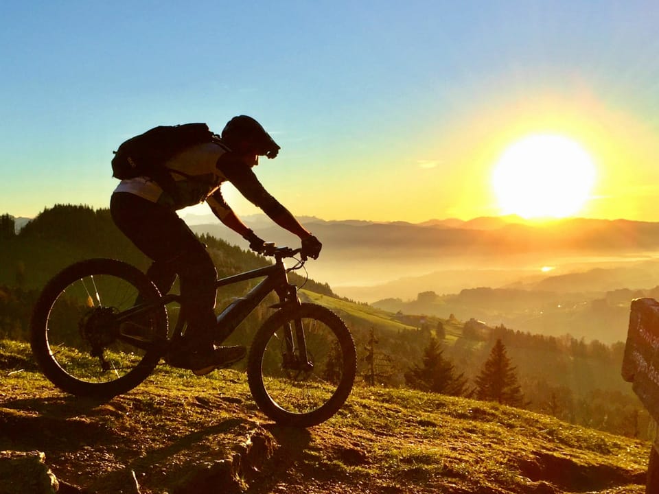 Biker in den Bergen während Sonnenaufgang.