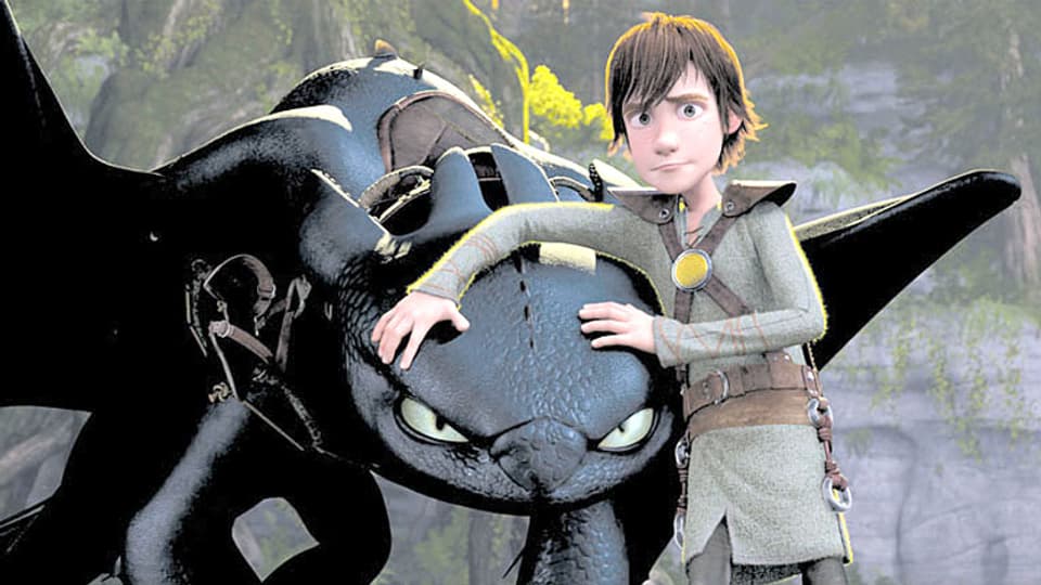 Der Wikinger Hicks hält schützend seine Arme über den Kopf eines Drachen.
