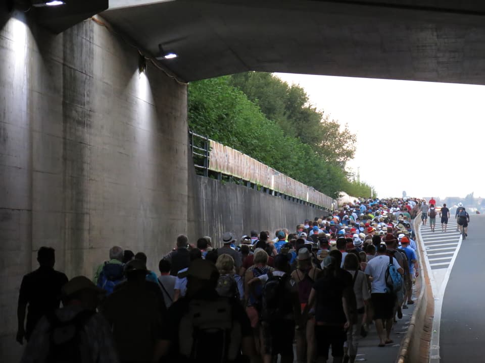 Viele Leute unter einer Brücke.
