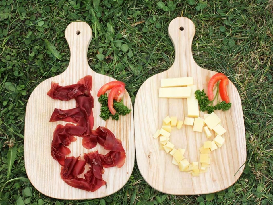 Ein Schlüssel aus Trockenfleisch und einer aus Käse auf einem Holzbrett.