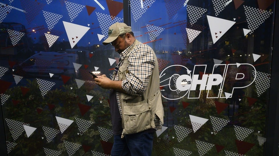 Ein Mann läuft an einem CHP-Logo vorbei