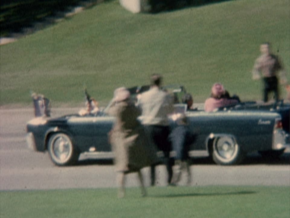 John F. Kennedy liegt verletzt in der Präsidenten-Limousine.