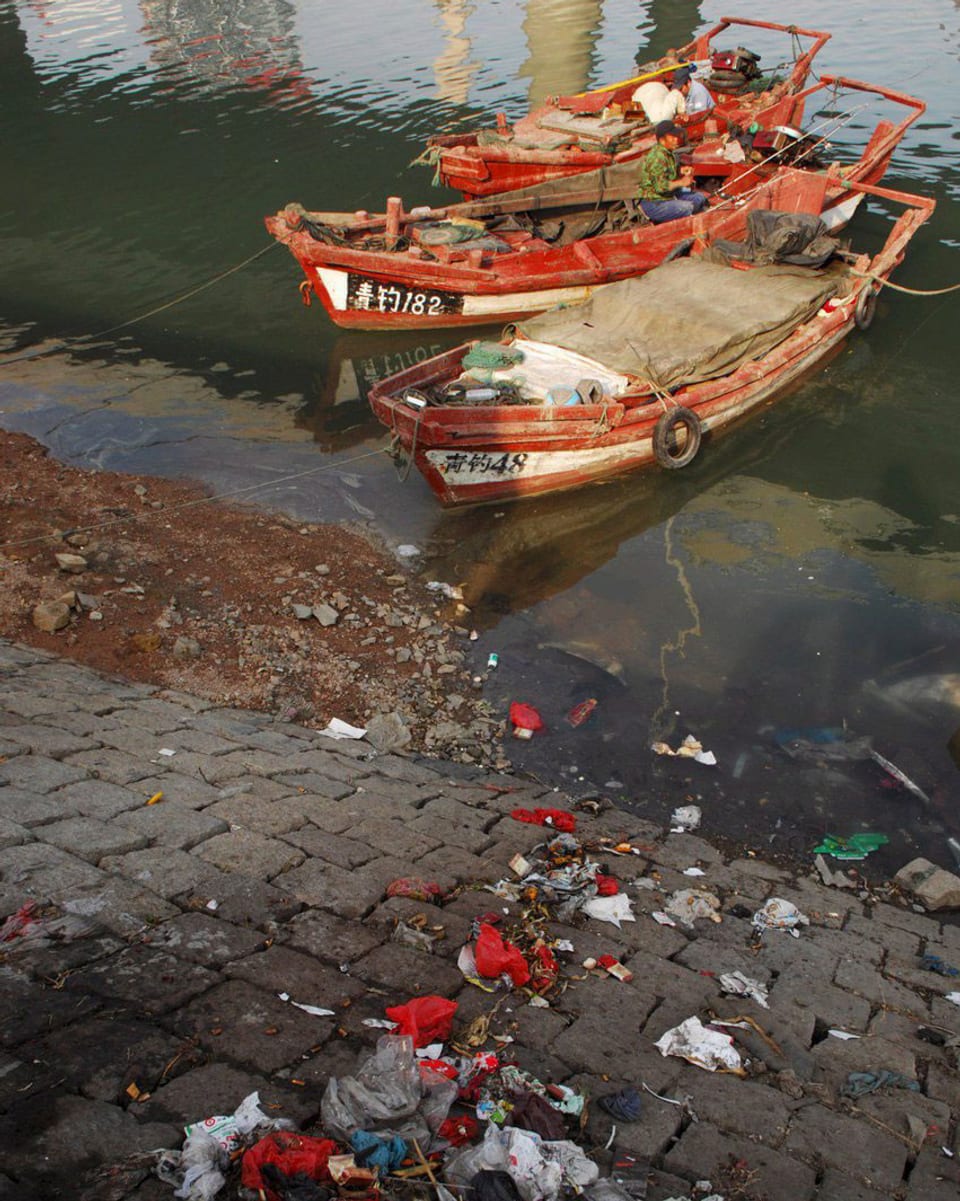 Zwei Schiffe, viel Plastikmüll: Hafenszene in China.