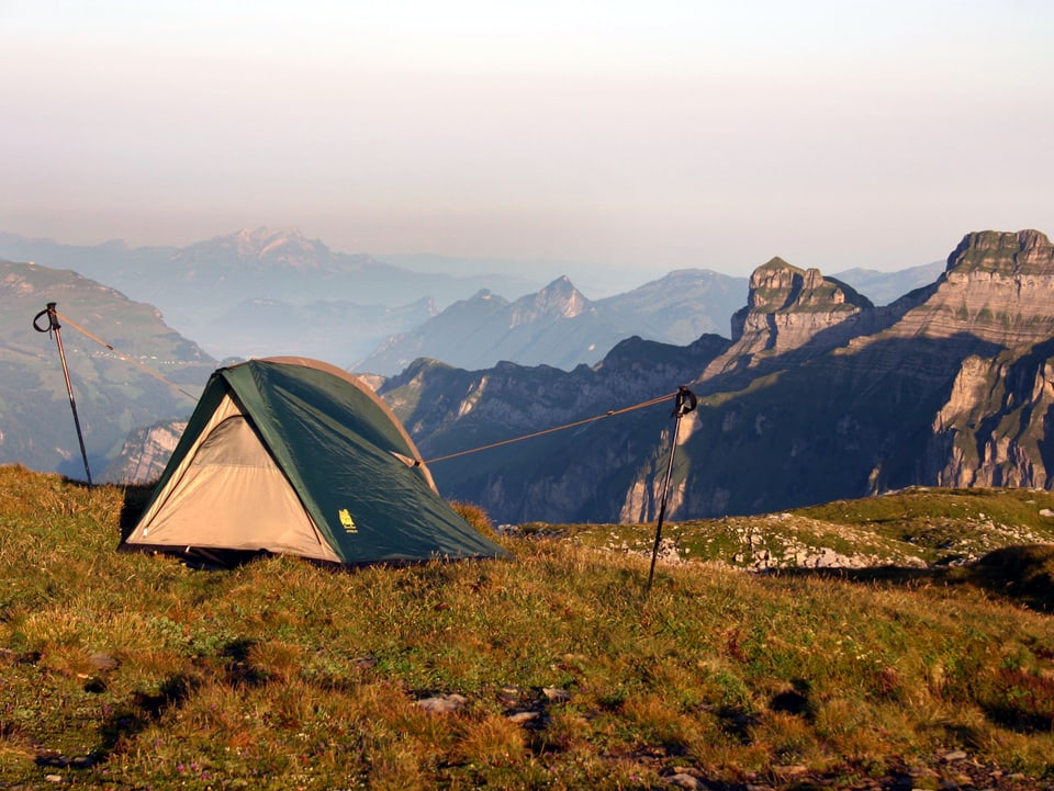 Zelt steht vor Alpenkulisse auf der Höhe.