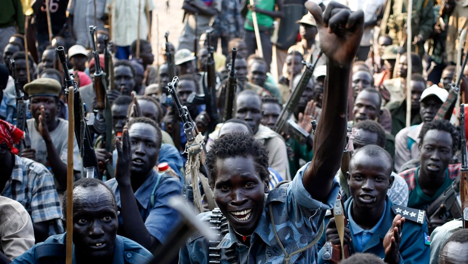 Schwerbeffnate Rebellen im Südsudan: Sie stemmen ihre Ärme in die Höhe. 