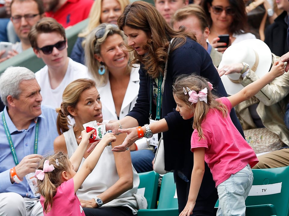 Mirka Federer den ZWillingen Charlene und Myla auf der Tribüne.