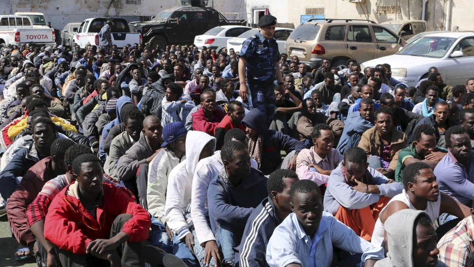 Illegale Migranten sitzen am Hafen von Tripolis, bewacht von der libyschen Marine (Oktober 2016)
