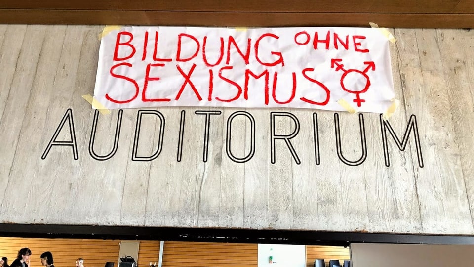Transparent mit der Aufschrift "Bildung ohne Sexismus" im Auditorium