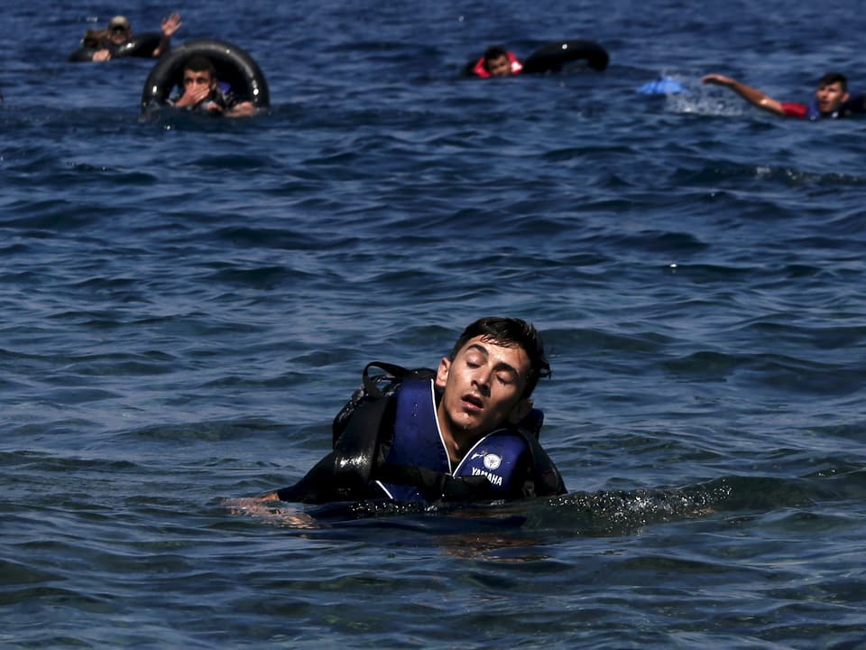Ein Flüchtlinge im Meer schliesst vor Erschöpfung die Augen 