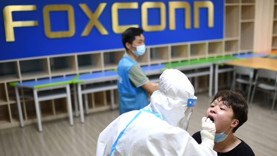 Ein Mann wird in der Foxconn-Fabrik einem Corona-Test unterzogen.