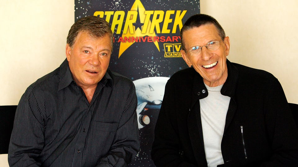 William Shatner (links) und Leonard Nimoy lächelnd in die Kamera blickend.