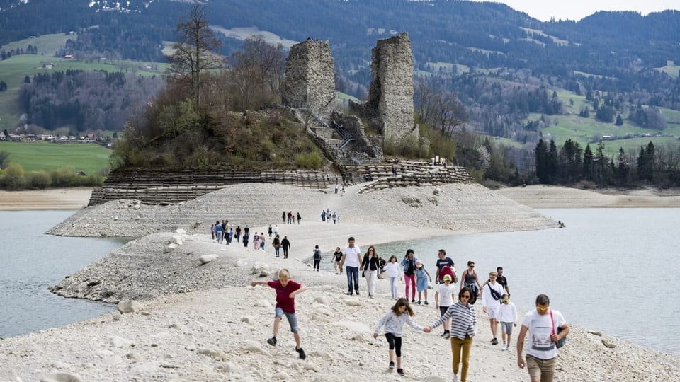 Touristinnen und Touristen spazieren zur Ruine.
