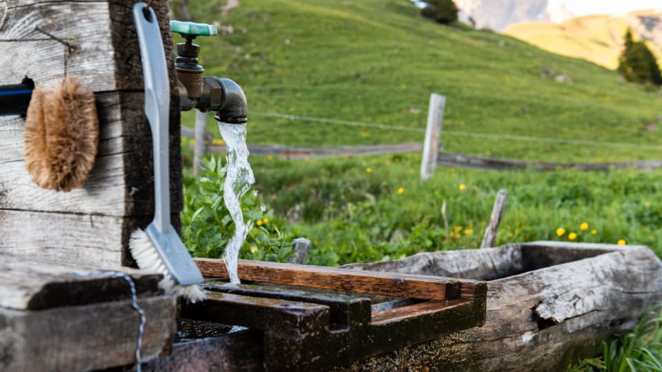 Ein Brunnen. Wasser läuft aus dem Wasserhahnen.