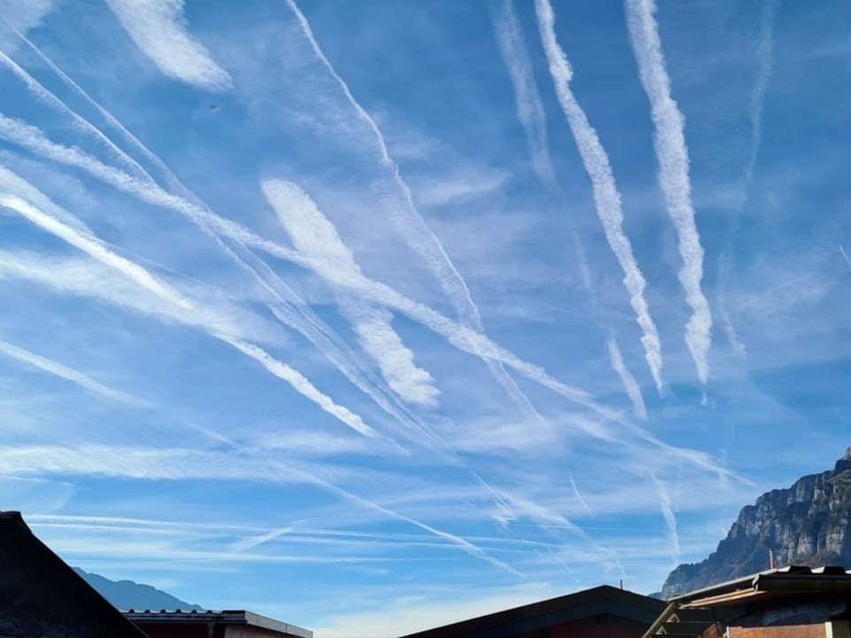 Blauer Himmel mit weissen Kondensstreifen.