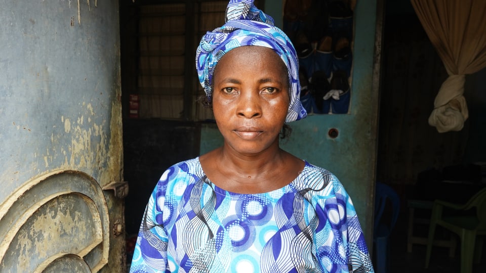 Ivorerin mit blauem Kleid und Kopftuch 