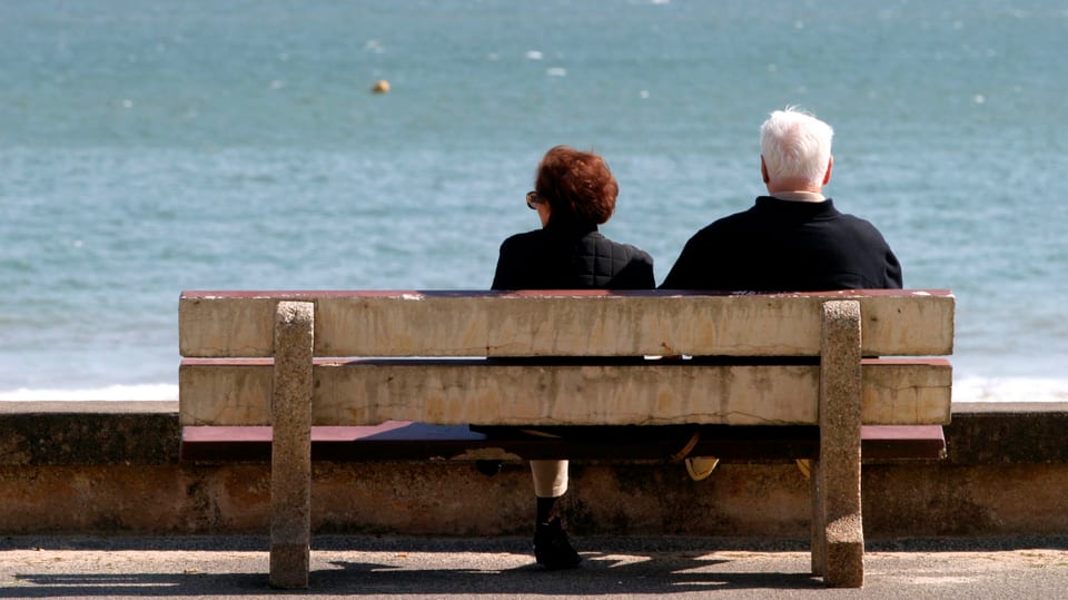 Zwei Rentner auf einer Bank am Meer