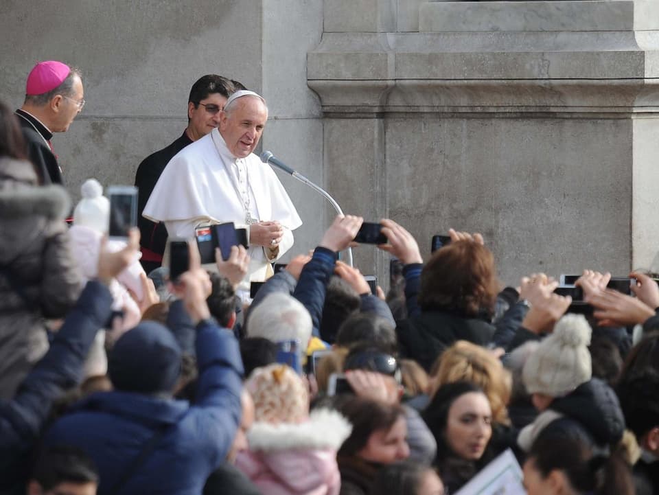 Der Papst an einem Mikrofon.
