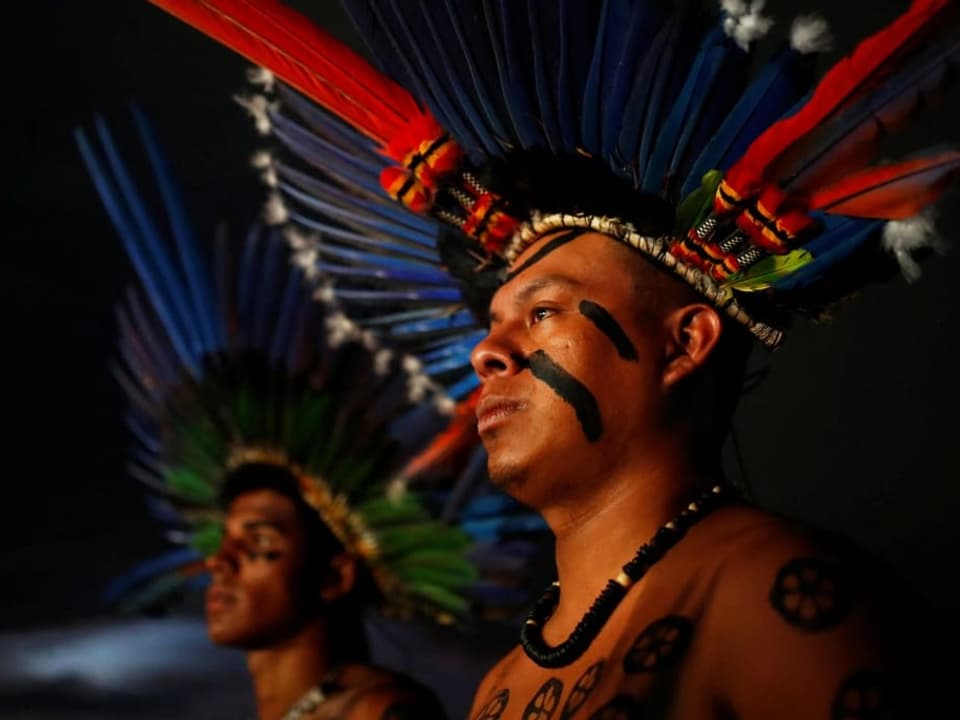 Zwei Indigene Mänenr mit Kopffedern