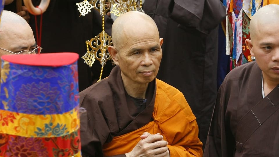 Mönch mit Glatze und orange-braunem Umhang