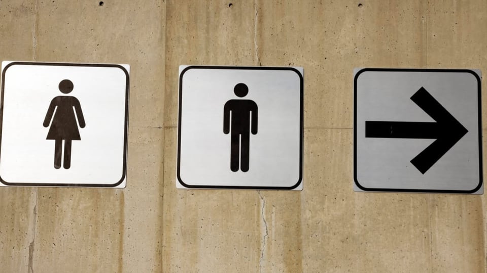 Schilder zeigen, wo sich die WCs für Frauen und Männer befinden.