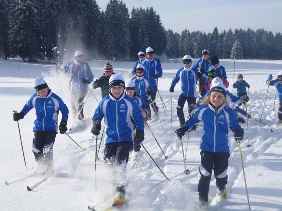 Kinder auf Skis im Tiefschnee