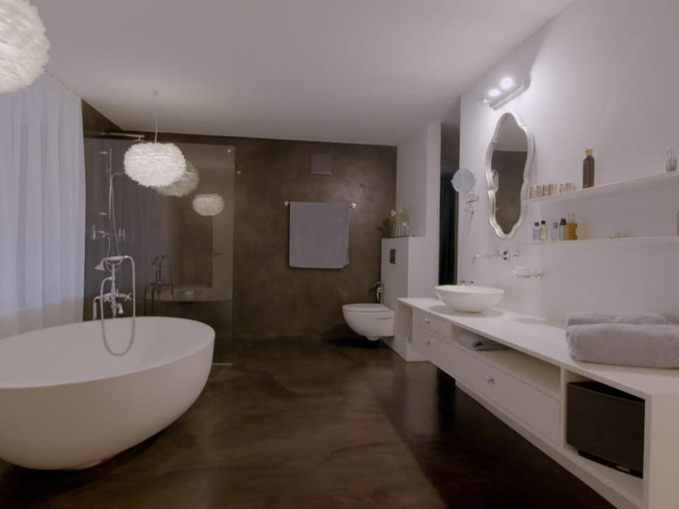 Ein grosses Badezimmer mit freistehender Badewanne und Dusche.